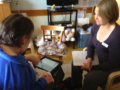 One of the participants in the trials of the iPads as assistive technologies undertaking training with research assistant Carolyn Bilsborow
